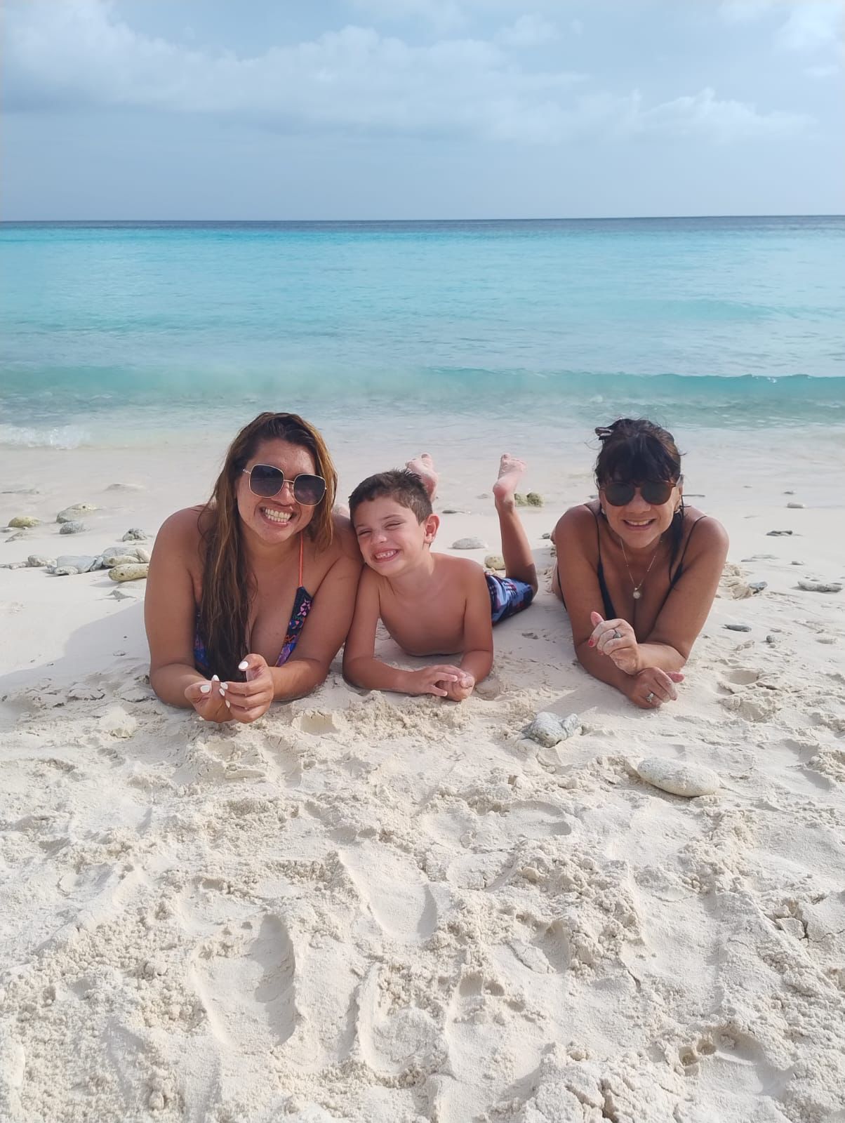 Mey con su hijo y su mamá en la playa del Caribe